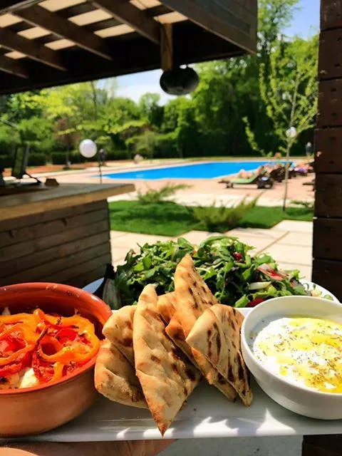 Mezze și pâine la grătar cu piscina în fundal